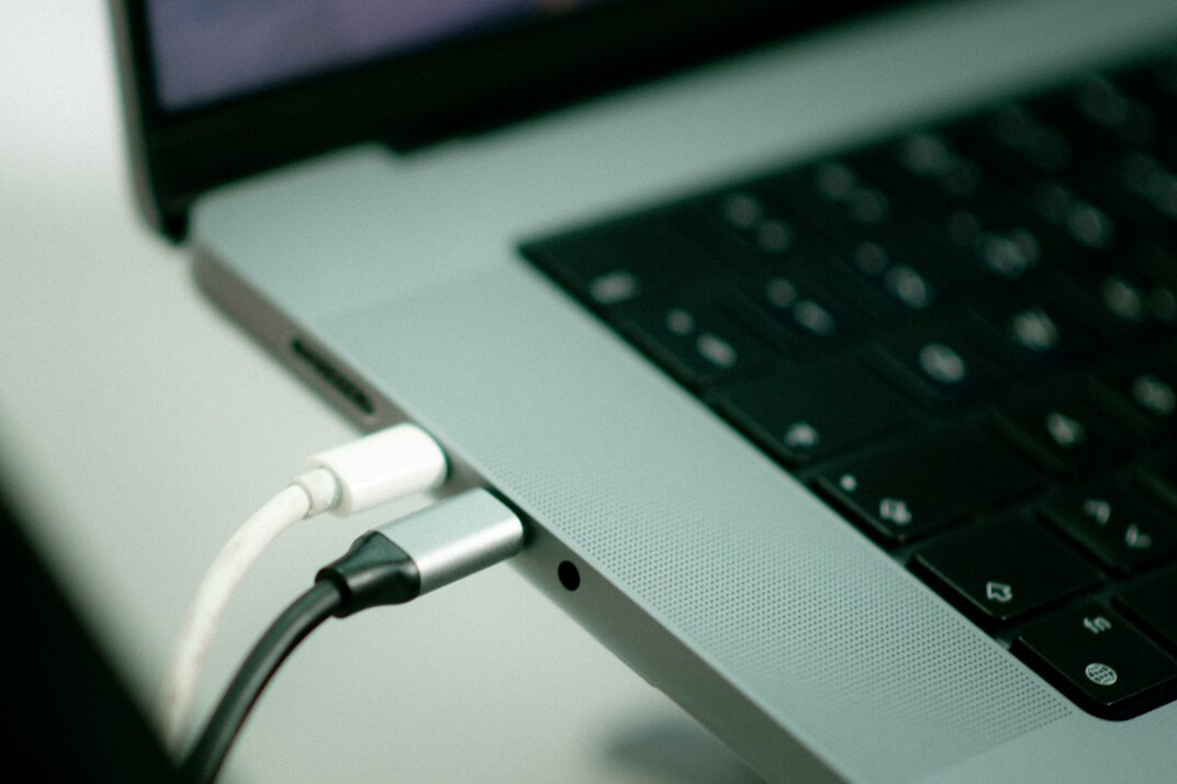 Laptop screen showing lines of code on a wooden desk